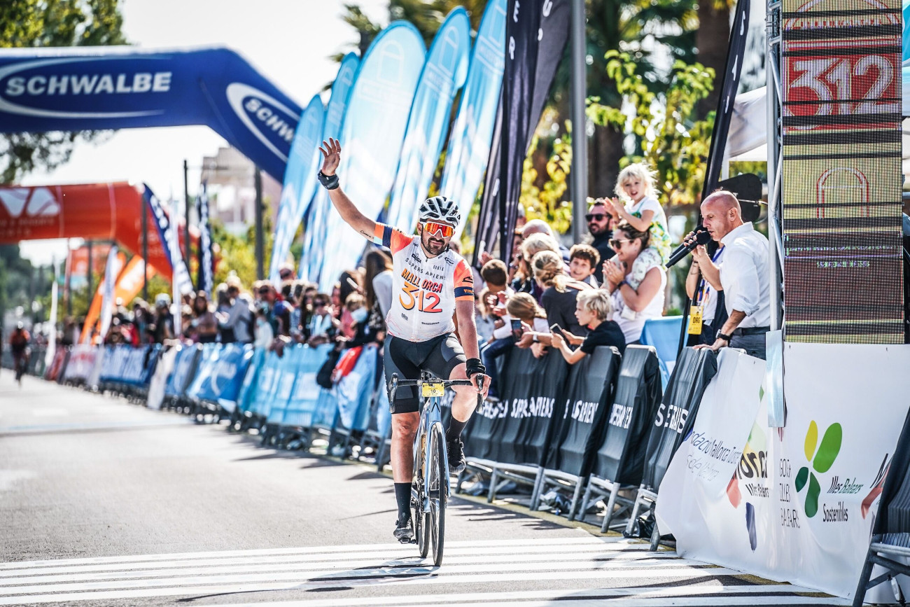 A cyclist waves to the crowd as they finish the Mallorca 312