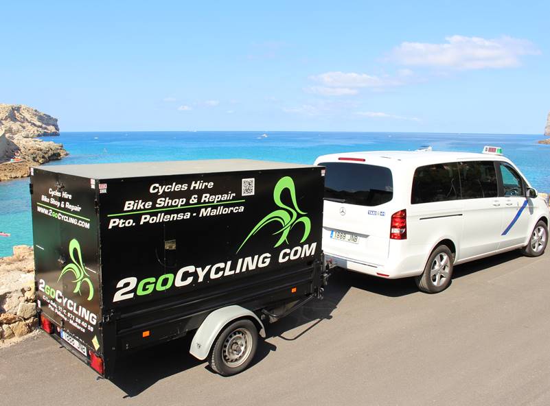 A large 9 seater minivan with a large trailer for carrying bikes