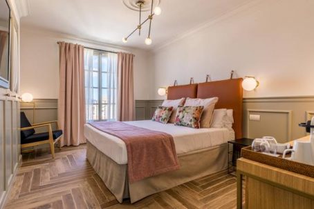 A bedroom with a large bed and a chair