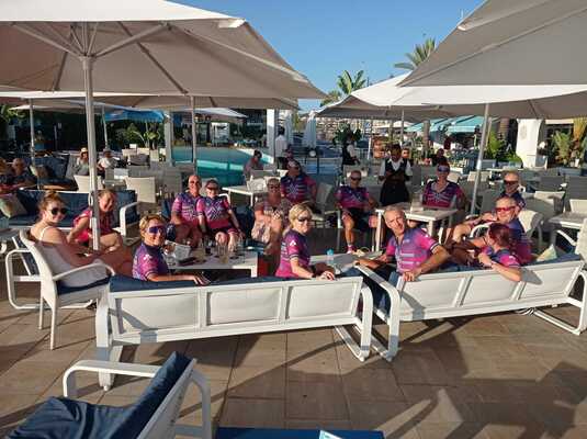 Cyclists sitting around a small tables at a hotel