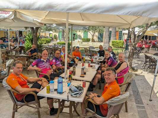 Cyclists sitting around a table in a cafe