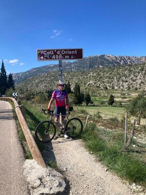 A cyclist in front of the Col d'Orient summit sign